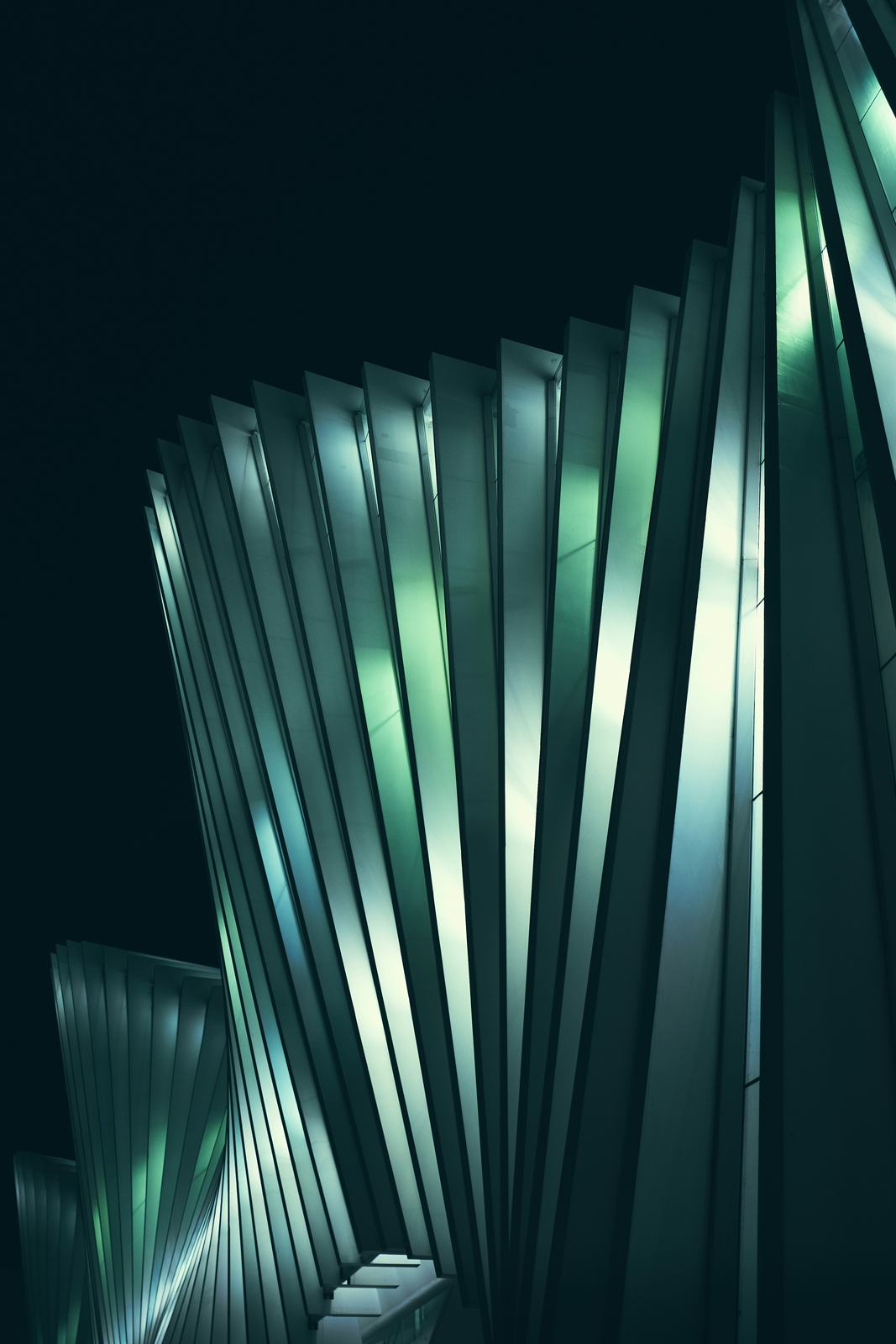 Glowing green-teal architectural fins against a black background